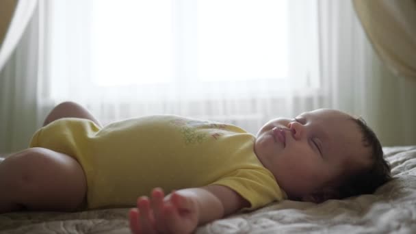 Zbliżenie śpiącego dziecka na tle okna — Wideo stockowe