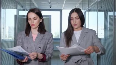 Gri ceketli, meşgul bir kadın müdürle konuşuyor.