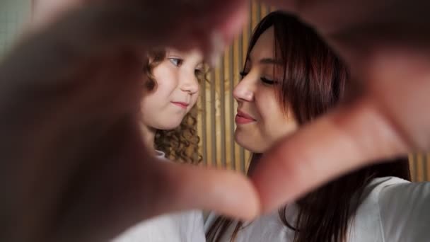 Glimlachende moeder en krullende dochter raken neuzen — Stockvideo