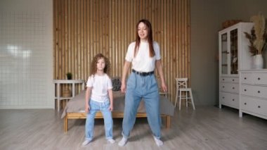 Kot pantolonlu neşeli anne ve çocuk dans eder ve beşlik çakar