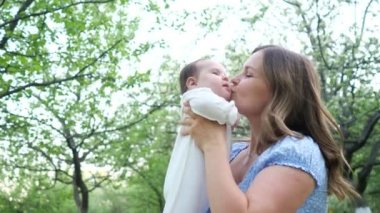 Sarı saçlı, mavi elbiseli genç kadın küçük kızını kucağına aldı.