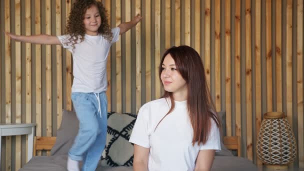 Kleuter meisje in t-shirt en jeans benadert moeder — Stockvideo