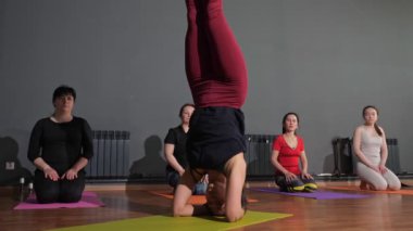 Deri giyim alanında profesyonel eğitmen Headstand 'ı icra ediyor.