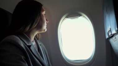 Pencereden bakan genç bir kadın.