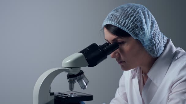 Žena unavená z prohlížení mikroskopem na pracovišti — Stock video