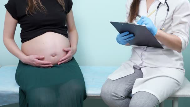 Gynecologist interviews pregnant lady in clinic office — Stock Video