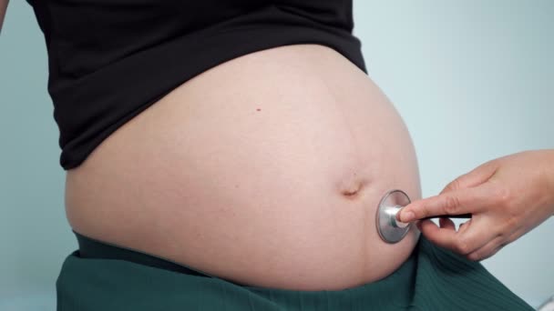 Médecin écoute femme enceinte avec stéthoscope en clinique — Video