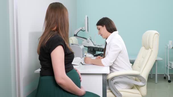 Femme médecin écrit examinant la patiente enceinte au bureau — Video