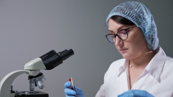 Υπάλληλος με γυαλιά παίρνει σταγόνα αίματος με πιπέτα στο εργαστήριο — Αρχείο Βίντεο