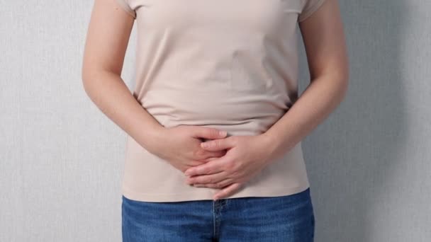Неузнаваемая женщина держит желудок в случае сильных болей — стоковое видео