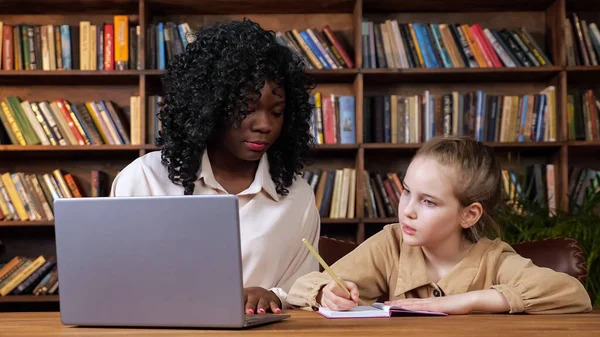 Bireysel öğretmen öğrenci materyalini açıklıyor ve kız yazıyor