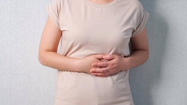 Karın ağrısı çeken tanınmayan bir kadın.