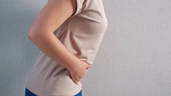 Mujer irreconocible sosteniendo el vientre con dolor severo, vista lateral — Foto de Stock