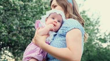 Dikkatli ol sarışın anne, ağlayan dişi çocuğu kucağına alır ve sakinleştirir.