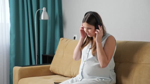 Mulher grávida gostando de ouvir música em fones de ouvido, câmera lenta — Vídeo de Stock