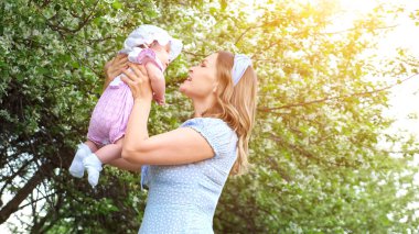 Genç bir kadın kollarında komik bir kız çocuğu ve öpüyor.