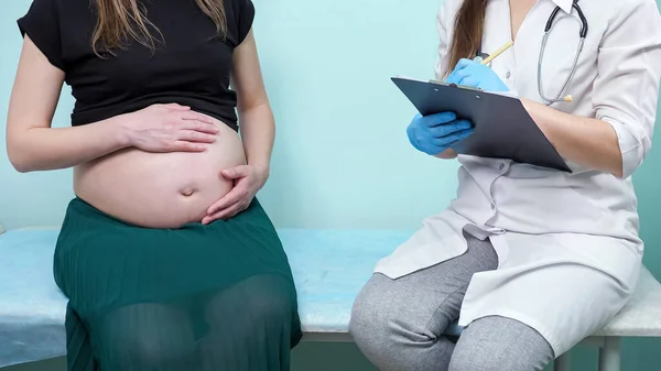 Gynécologue entretiens femme enceinte dans le bureau de la clinique — Photo