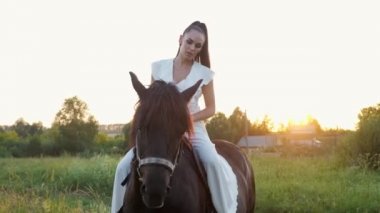 Atkuyruklu esmer kadın binici ata biniyor.