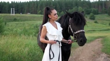 Profesyonel model esmer siyah aygır dizgini taşıyor.