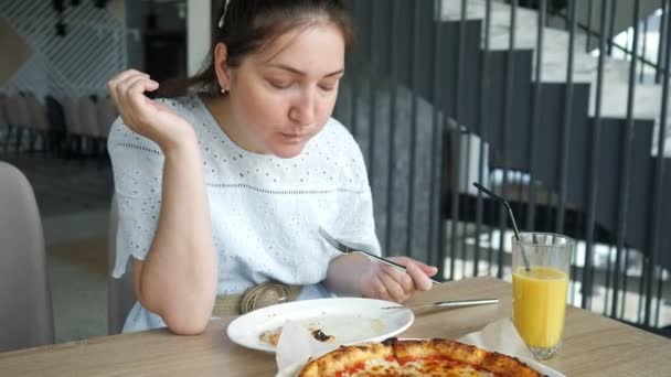 Lady eet pizza genieten in het restaurant — Stockvideo