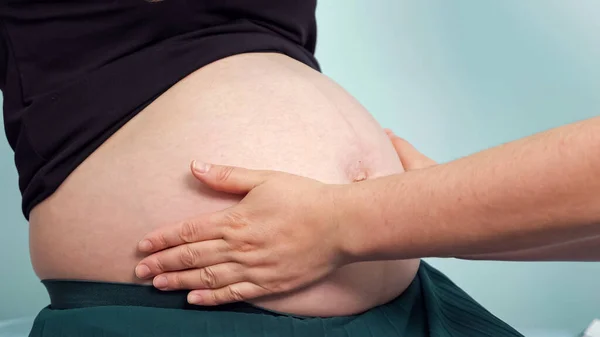 Médecin vérifie femme enceinte gros ventre dans le bureau de la clinique — Photo