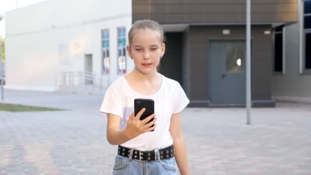 Залежність від смартфона дівчина-підліток дивиться на дисплей під час руху — стокове відео