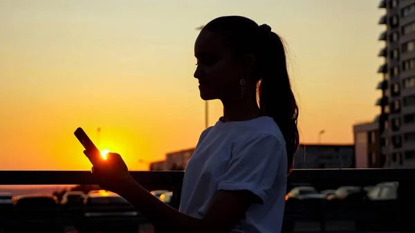 Závislý mladý dospívající dívka s culíkem drží smartphone — Stock fotografie