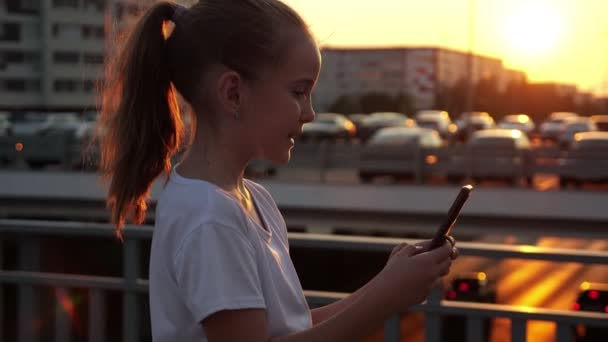 Meisjes typen op smartphone en poseert voor selfie bij zonsondergang — Stockvideo