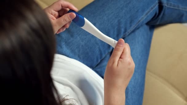 Unerkannte Frau dreht positiven Schwangerschaftstest, um das Ergebnis herauszufinden — Stockvideo