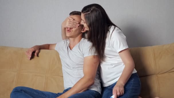 Boldog férfi és nő terhességi teszt kanapén — Stock videók