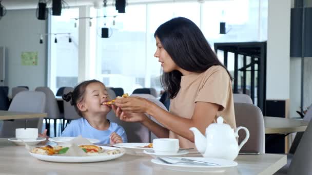 Lady ibu memegang pizza slice dan anak makan di kafe — Stok Video