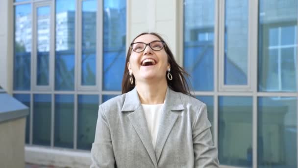 Vrouw in een zakenpak loopt en gooit graag documenten op straat, slow motion — Stockvideo