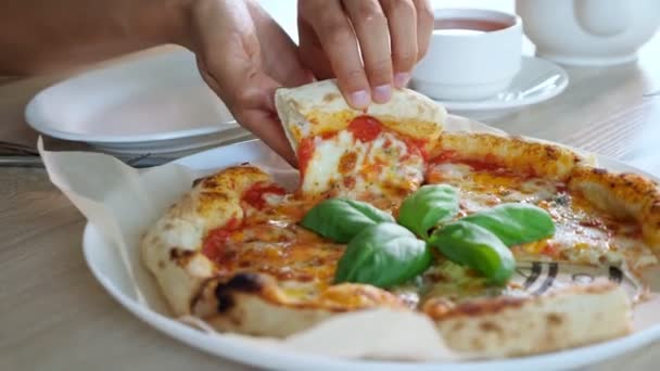 Wanita muda tangan mengambil sepotong pizza dan menempatkan di piring di kafe — Stok Video