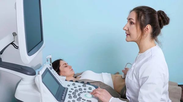 Médico sonriente hace ultrasonografía a la mujer en el hospital — Foto de Stock