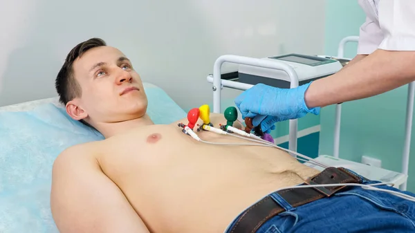 Enfermera pone electrodos en el hombre paciente para hacer electrocardiograma — Foto de Stock