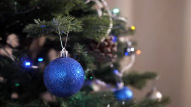 Mavi topun ve yapay Noel ağacındaki ışıltılı çelengin yakın çekimi