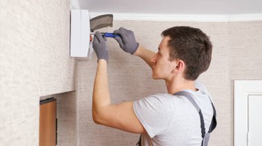 Üniformalı işçiler santral üzerinde kasa vidalarlar