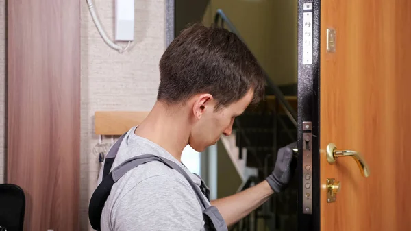 Kézműves ellenőrzi bejárati ajtó zár csavaró kar a szobában — Stock Fotó