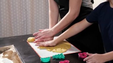 Tanımlanamayan kadın ve çocuk hamurdan farklı şekiller kesiyor.