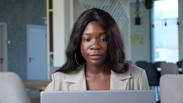 Afro-americká žena mluví na videochatu přes notebook v kavárně — Stock video