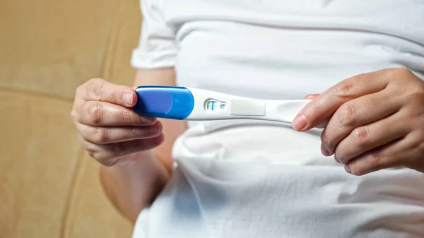 Femme méconnaissable tourne test de grossesse positif à la caméra — Photo