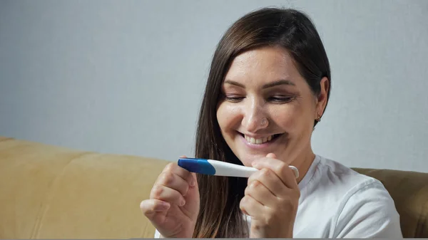 Gros plan de la jeune femme regardant joyeusement le test de grossesse — Photo