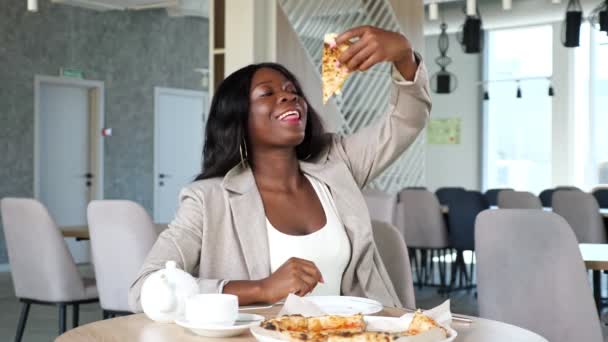 アフリカ系アメリカ人女性がカフェでおいしいピザを楽しむ — ストック動画