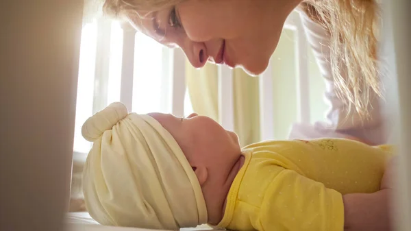 Joyeuse jeune mère embrasse bébé fille en vêtements jaunes — Photo