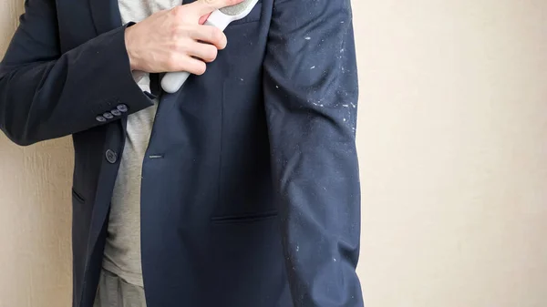 Man cleans jacket from animal hair with electrostatic clothing hair — Stock Photo, Image