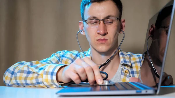 Mann mit Brille diagnostiziert Laptop mit Phonendoskop — Stockfoto