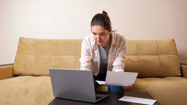 Mulher bonita com conta calcula pagamentos no laptop — Fotografia de Stock