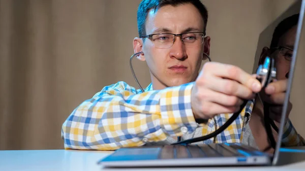 Junger Mann diagnostiziert Laptop mit Phonendoskop — Stockfoto