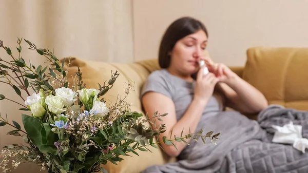 Señora borrosa con flores alergia estornudos en servilleta de papel — Foto de Stock