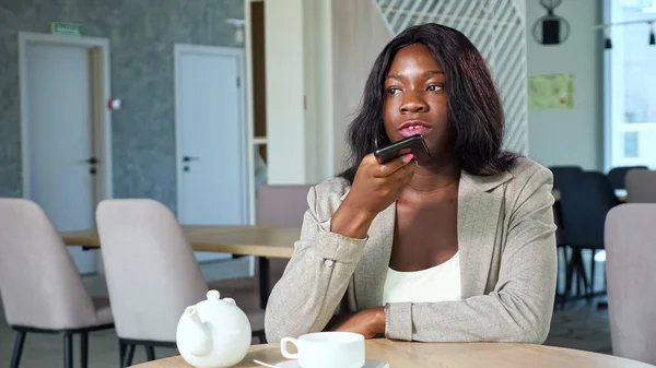 Mujer afroamericana graba mensaje de audio en la cafetería —  Fotos de Stock